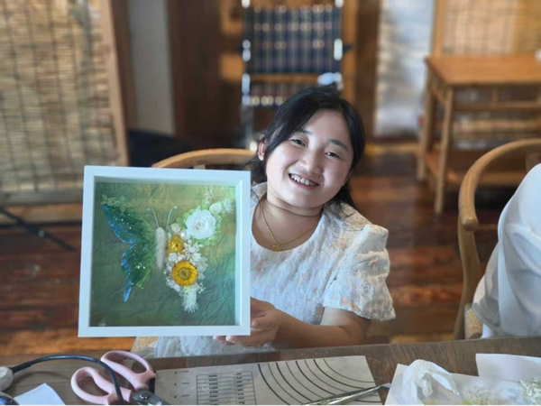 宮燕將培訓中學到的永生花工藝，與毛線鉤針技藝相結合，設計制作出永生花蝴蝶相框。