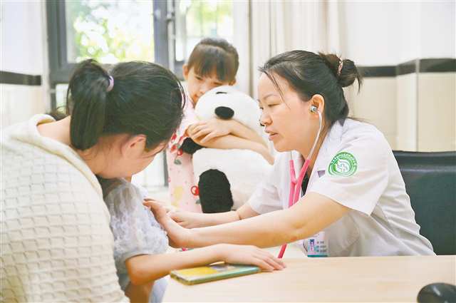 賀良萍正在為兒童患者看診，她準備了熊貓玩偶幫助孩子克服恐懼。