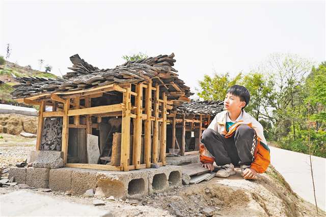 鄒君潔和他復刻的吊腳樓。（本組圖片由市委文明辦提供）