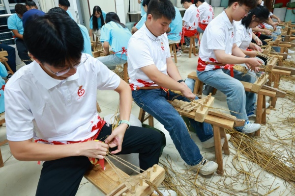 成員們體驗編草鞋。重慶工商職業學院供圖
