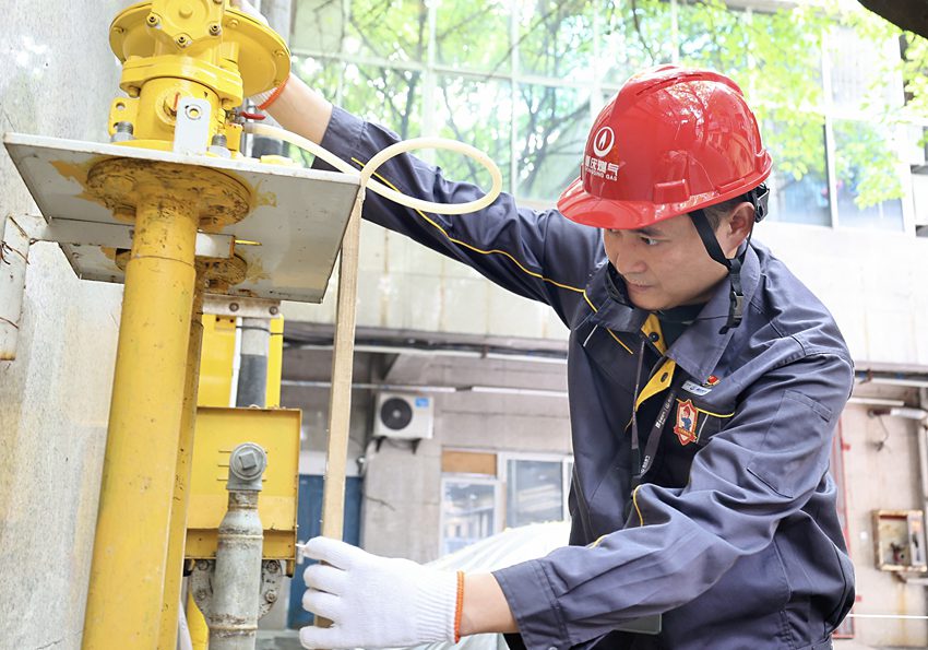 渝中區大禮堂好吃街旁，“紅巖燃小兵”對燃氣調壓箱進行日常運行維護。重慶燃氣集團供圖