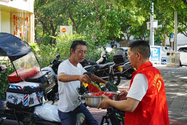 社區志愿服務隊為新就業群體送清涼物資。龍山街道供圖