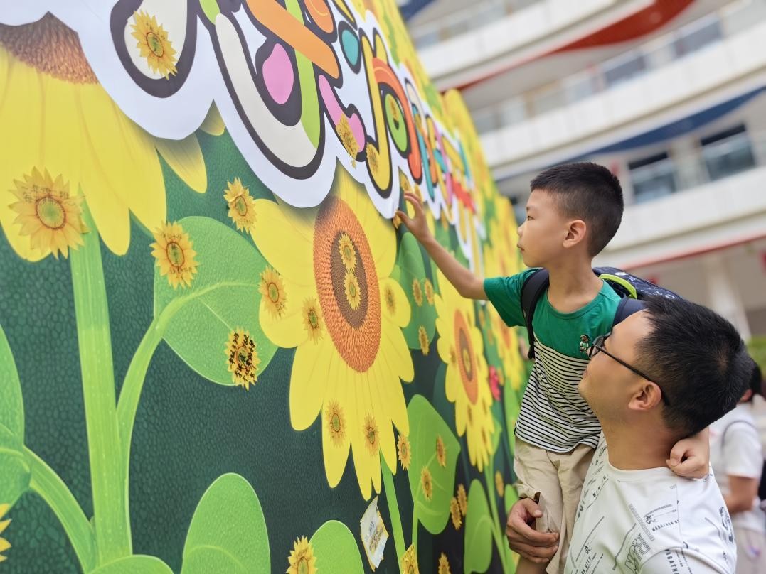北碚區兩江春暉小學一年級新生在“葵花墻”上貼上小心愿。周輝攝