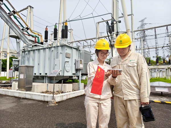 9月3日，在110千伏匯龍變電站，國網永川供電公司雷柳等人開展現場測溫工作之余，用手機收看紀念大會和閱兵儀式直播。吳京鴻攝