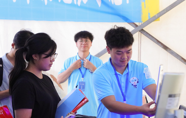 志愿者幫助新生處理報道流程。重慶城市科技學院供圖