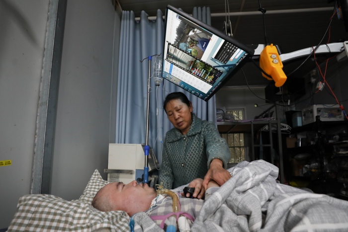 “重慶好人”黎夏用兩根指頭遙控農場的自動化系統。渝北區委宣傳部供圖