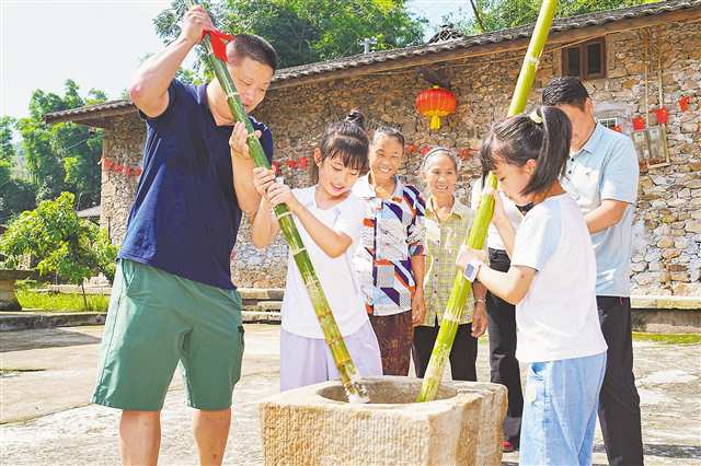 10月6日，在北碚區金刀峽鎮勝天湖村“九斗碗壩壩席”活動現場，游客在體驗打糍粑。特約攝影 秦廷富/視覺重慶