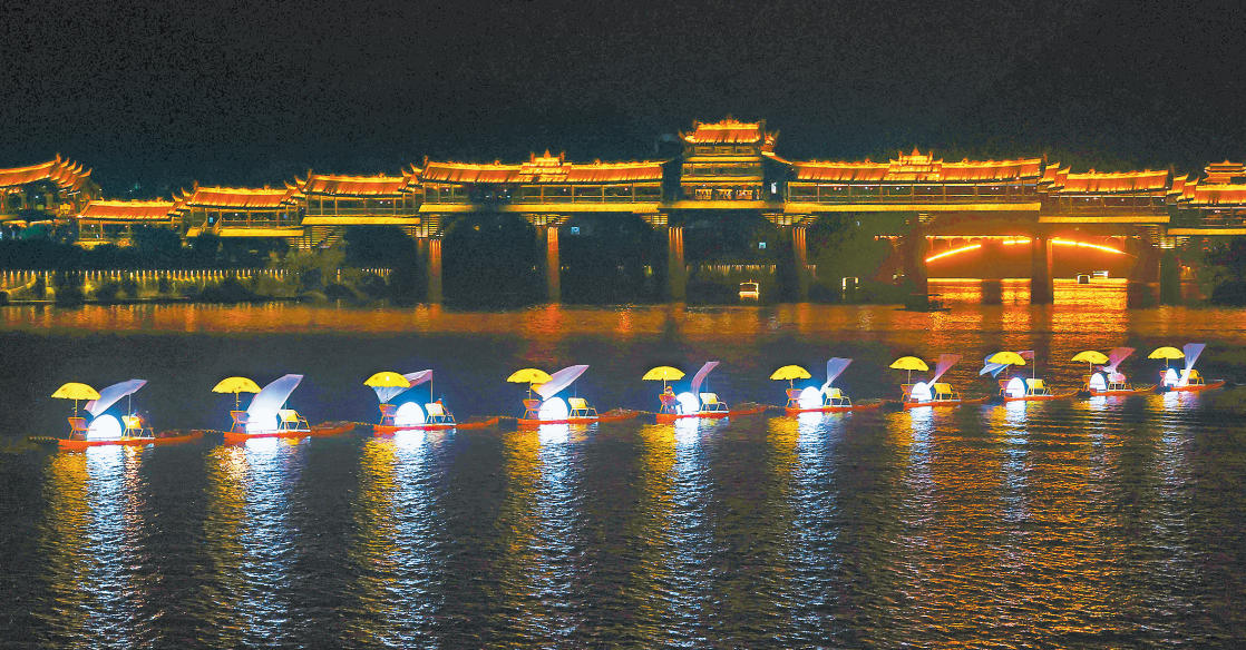 10月5日，黔江區濯水古鎮阿蓬江上，演藝人員為游客表演鵲舟游。  　　國慶、中秋假日期間，黔江區濯水古鎮開展夜游阿蓬江活動，在阿蓬江上表演火壺、打鐵花、花船巡游、水上飛人等項目，演繹了一場夜幕下的水上文化盛宴，吸引了眾多游客前往觀賞。特約攝影 楊敏/視覺重慶