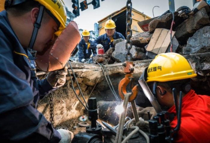 近日，大渡口區鋼花路，搶險班班長劉瀚林和同事李學武在閥井作業坑里焊接燃氣主管閥門。記者 張錦輝 攝/視覺重慶
