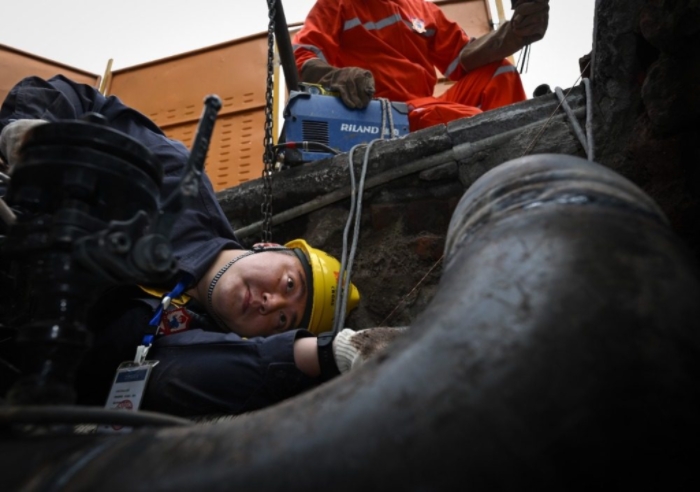 近日，大渡口區鋼花路，搶險班班長劉瀚林在閥井作業坑里檢查焊口焊接質量。記者 張錦輝 攝/視覺重慶