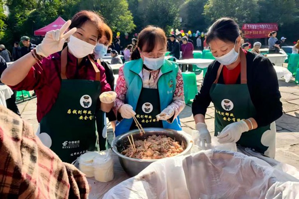 二居社區志愿者與居民一起包餃子。主辦方供圖