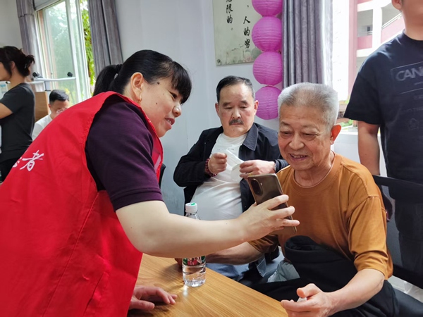 志愿者在幫助老年人使用數字關愛平臺。受訪者供圖